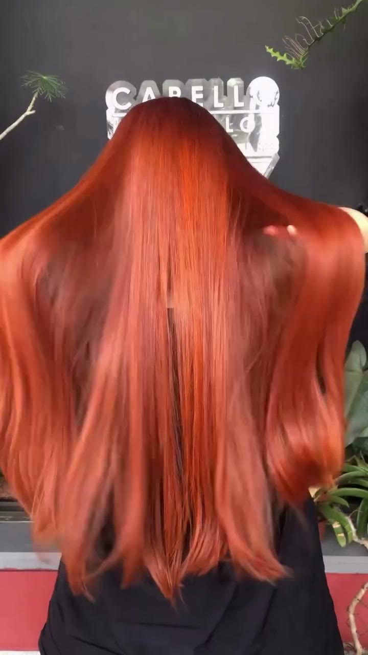 Cabello cobre liso y brillante frente al letrero de Capello
